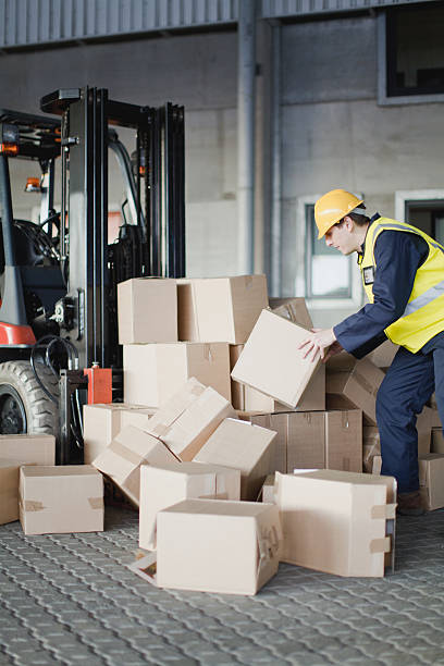 worker-loading-boxes-onto-forklift-picture-id129944686-2386415488